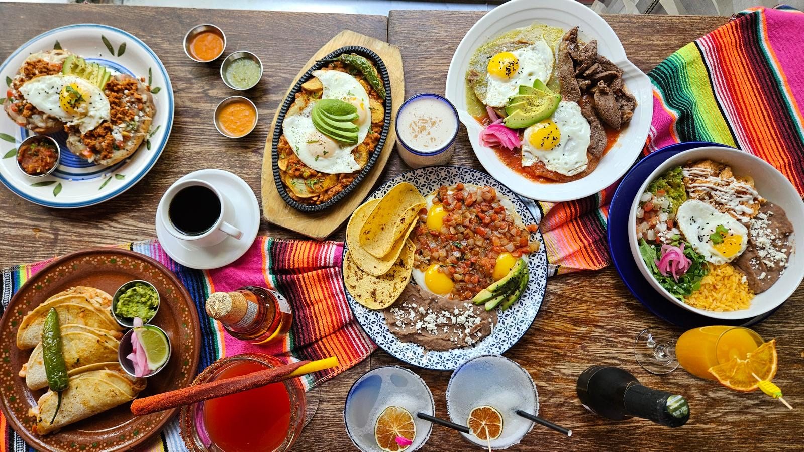 Sunday brunch spread of chilaquiles, huevos and beef on clay plates