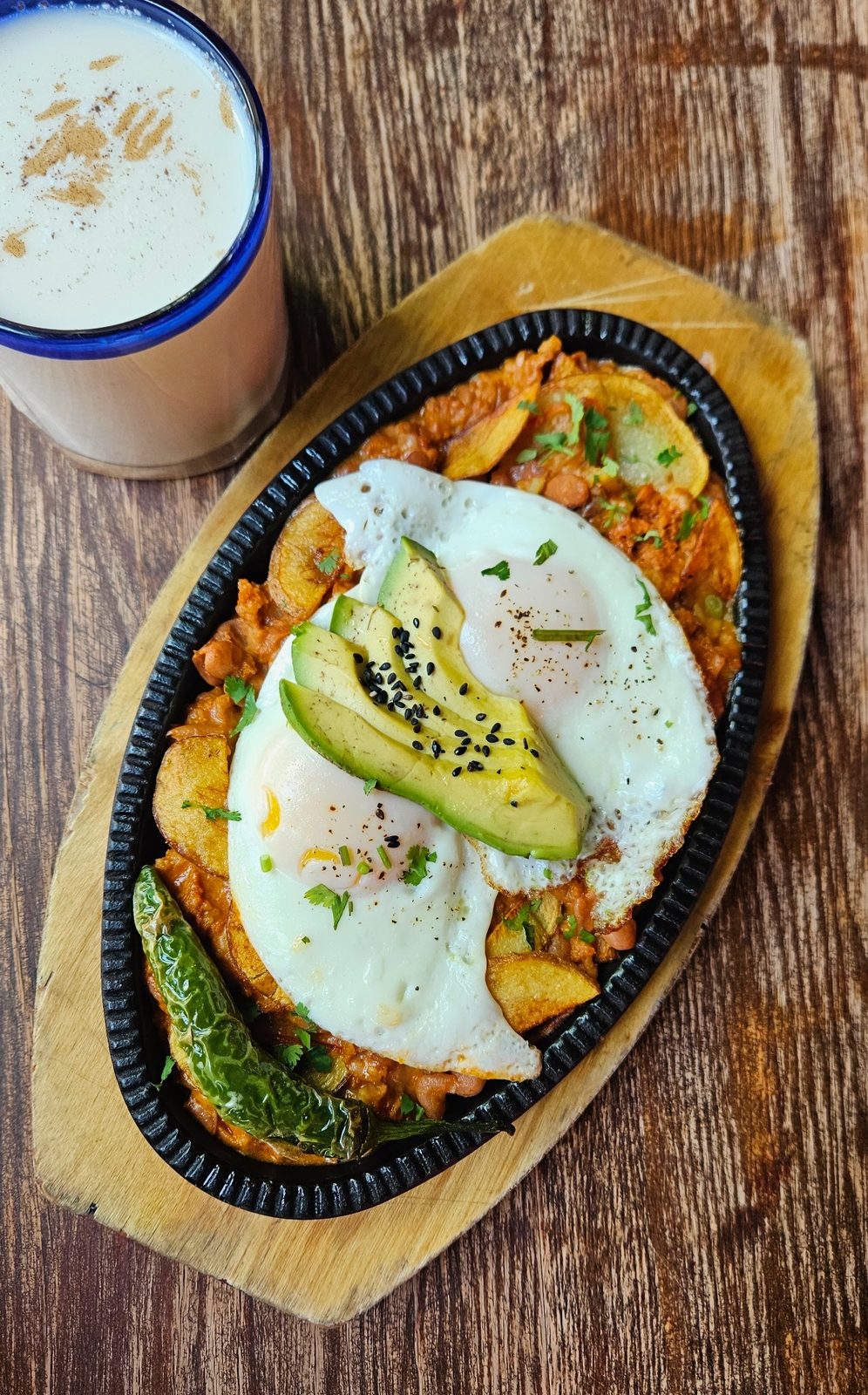 Tradicional Molletes open-faced sandwich with chorizo, melted cheese and a fried egg