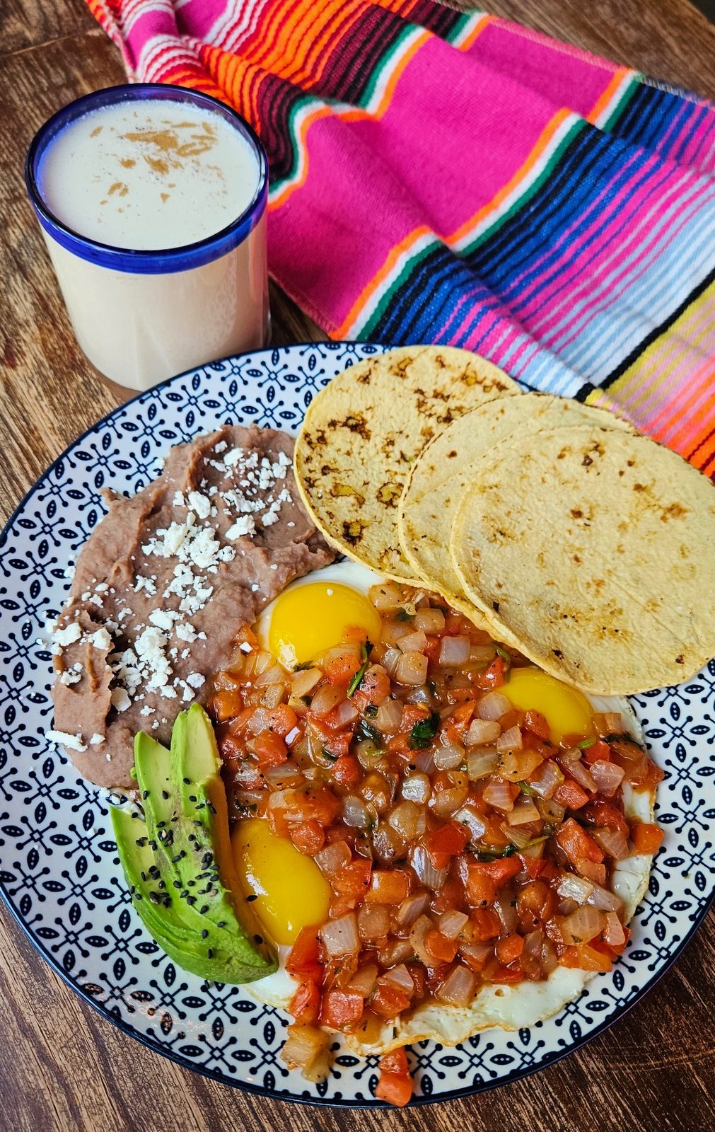 Huevos Divorciados with two fried eggs on corn tortillas, red and green sauces and sliced top sirloin