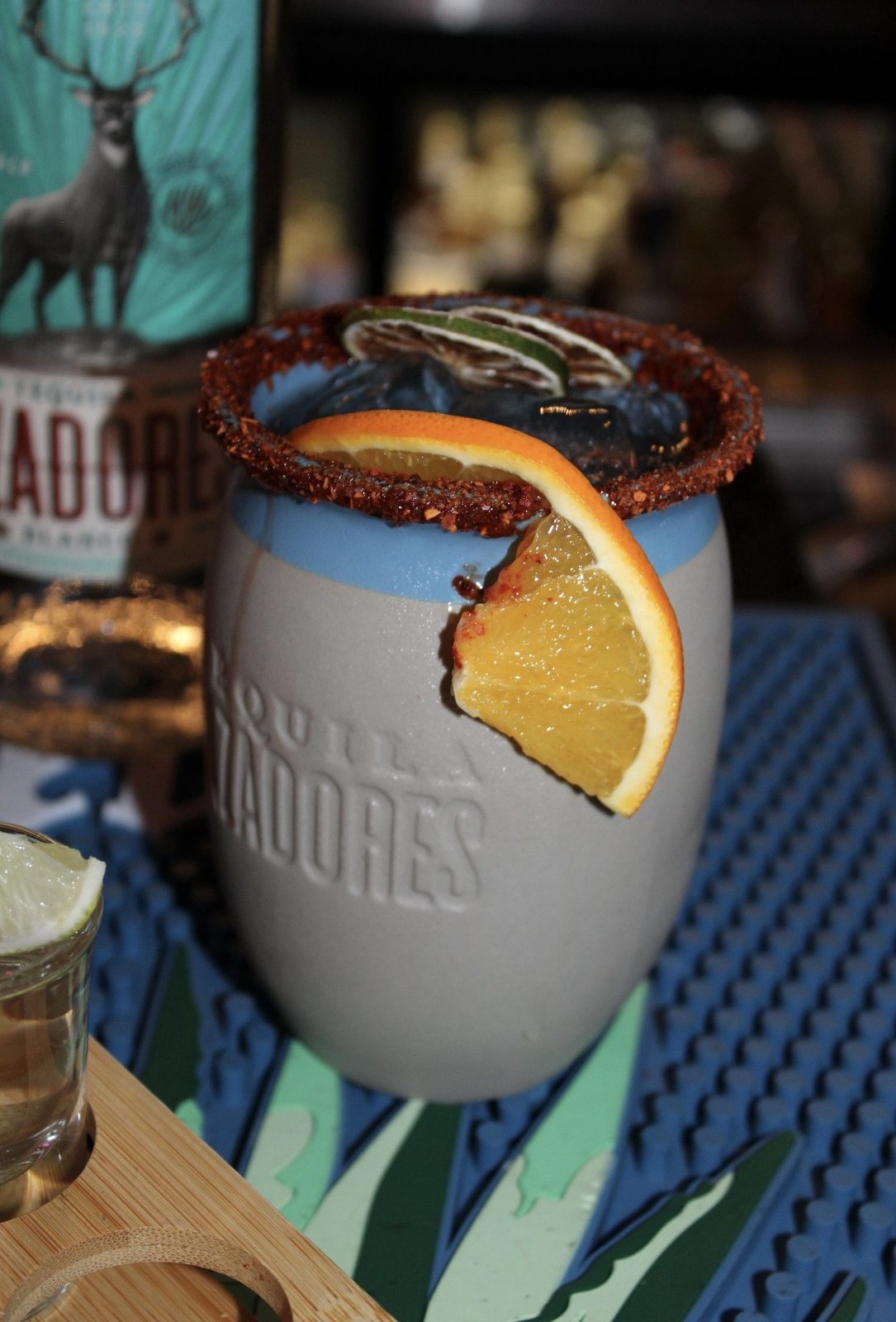 Cantarito served in a traditional clay cup with citrus and Tajín rim